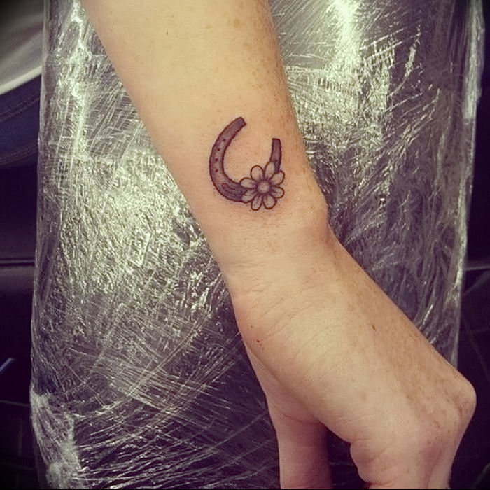 Tiny microrealistic horseshoe tattoo located on the