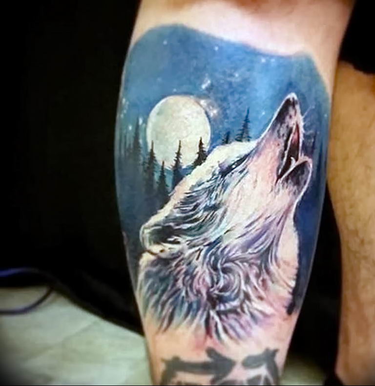 Тату волк воет на луну на руке